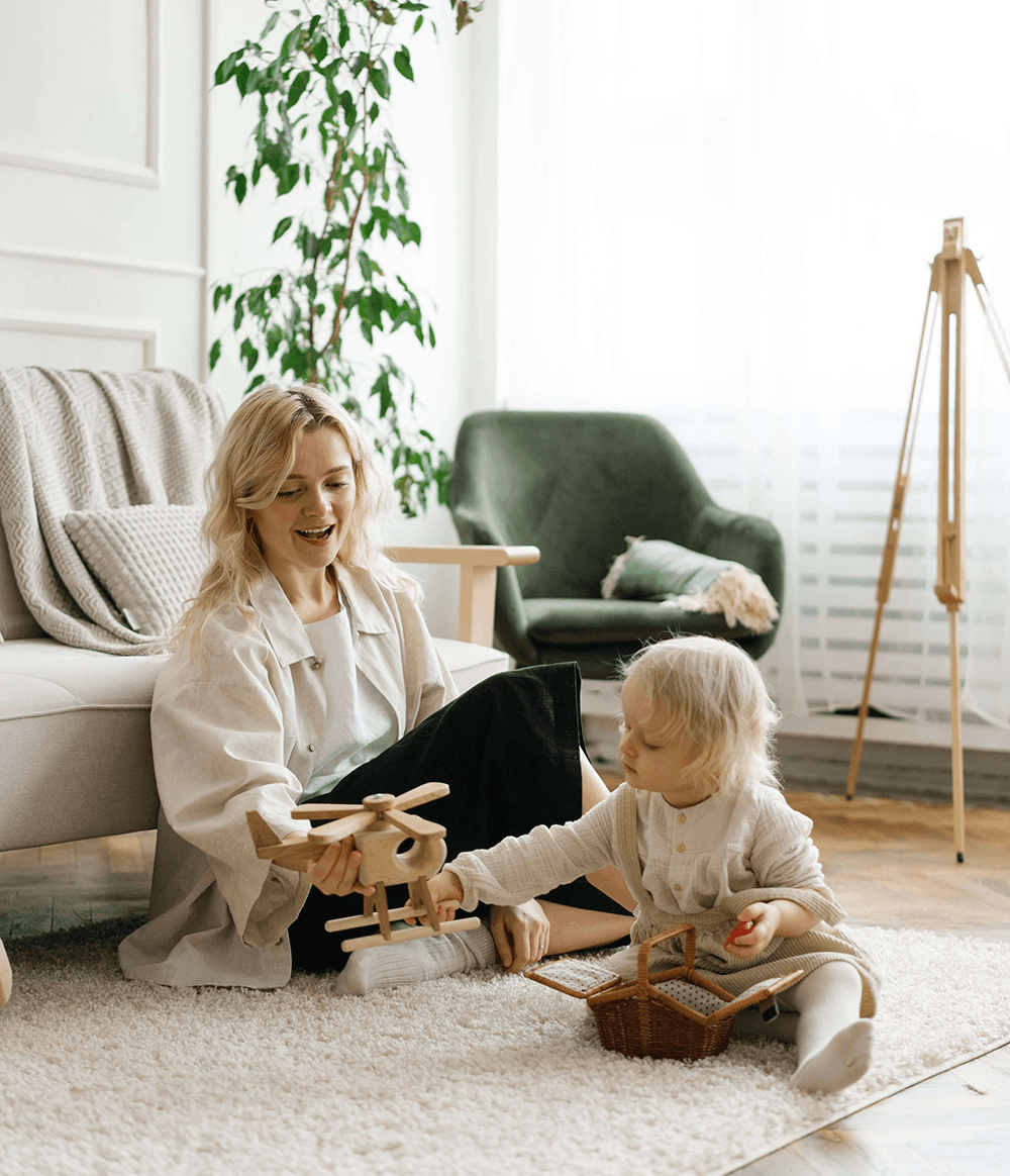 Parent reviewing nanny records at home with child nearby